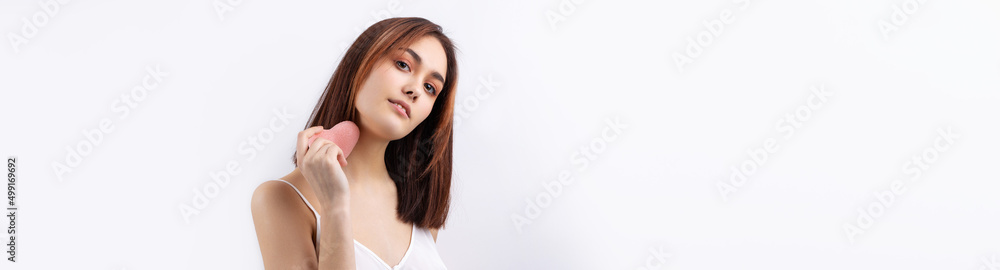 Beautiful smiling woman with clean skin, natural make-up and white teeth on a gray background. Holding a pink hygienic heart. Beautiful smiling woman with clean skin, natural make-up and white teeth on a gray background. Holding a pink hygienic heart.