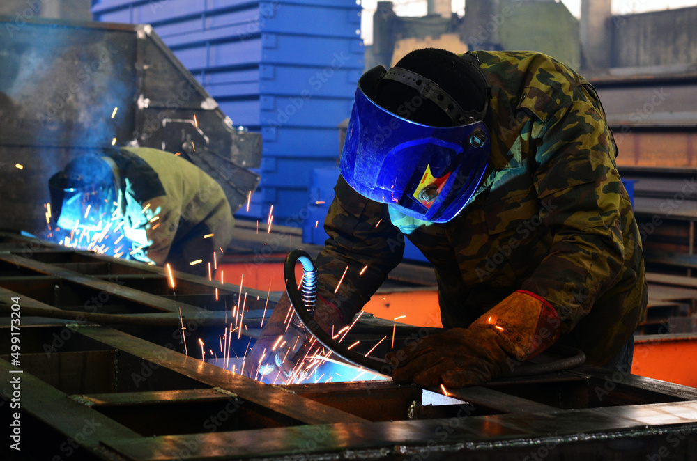 the welder at the factory cooks the structure the welder at the factory cooks the structure