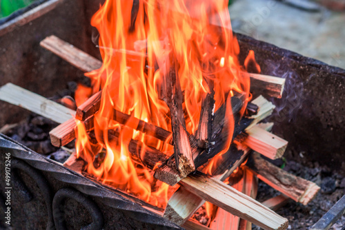 Burning firewood in barbecue grill