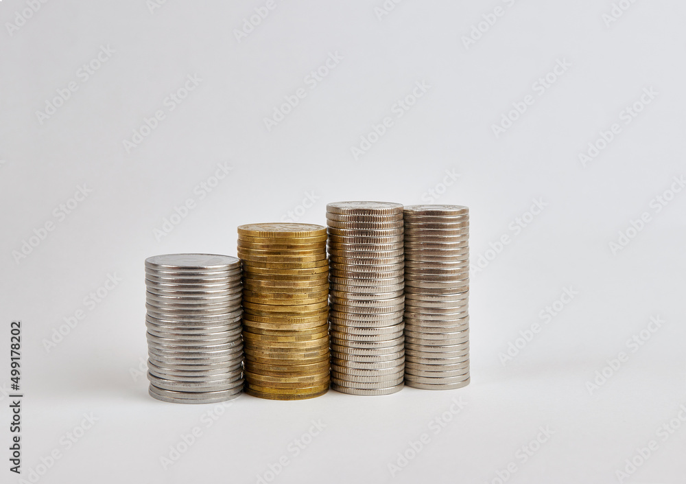 Four towers with coins of different denominations on a white background. Four towers with coins of different denominations on a white background.