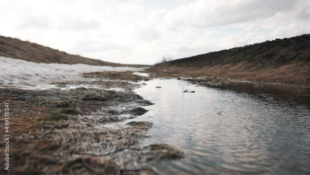 nature end of winter. large puddle on soil sky reflection in water landscape. motion camera steadicam a nature spring concept. dry grass water melts snow. beautiful field forest in spring snow melts nature end of winter. large puddle on soil sky reflection in water landscape. motion camera steadicam a nature spring concept. dry grass water melts snow. beautiful field forest in spring snow melts