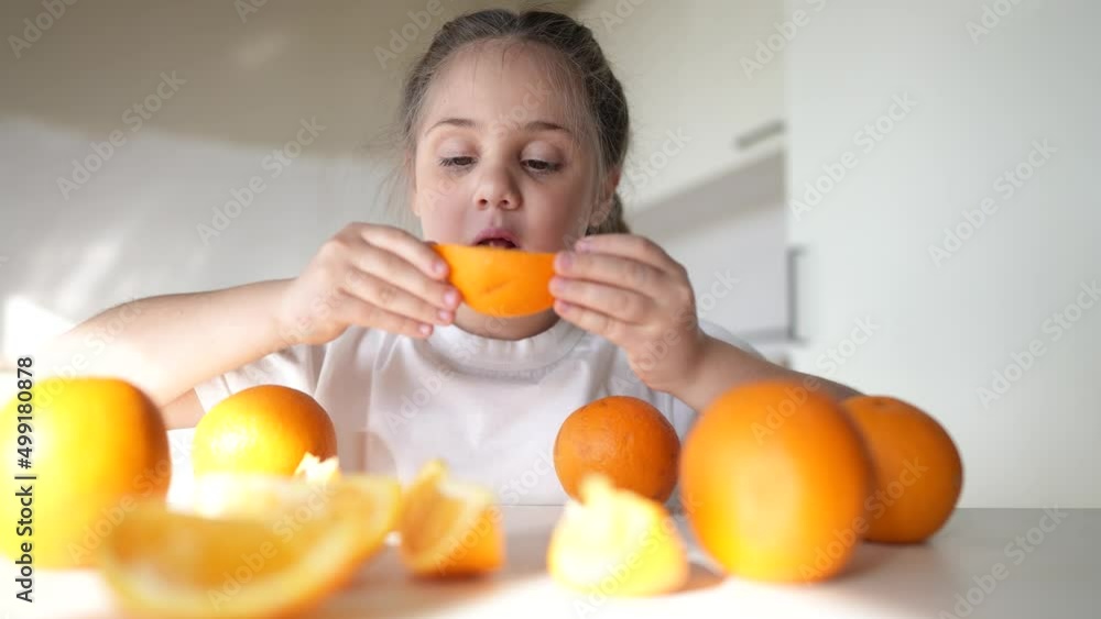 girl child eating oranges. happy family fruit healthy food kid concept. little girl daughter eating oranges at the table in the kitchen dream indoors. juicy fruits oranges are for a healthy diet girl child eating oranges. happy family fruit healthy food kid concept. little girl daughter eating oranges at the table in the kitchen dream indoors. juicy fruits oranges are for a healthy diet