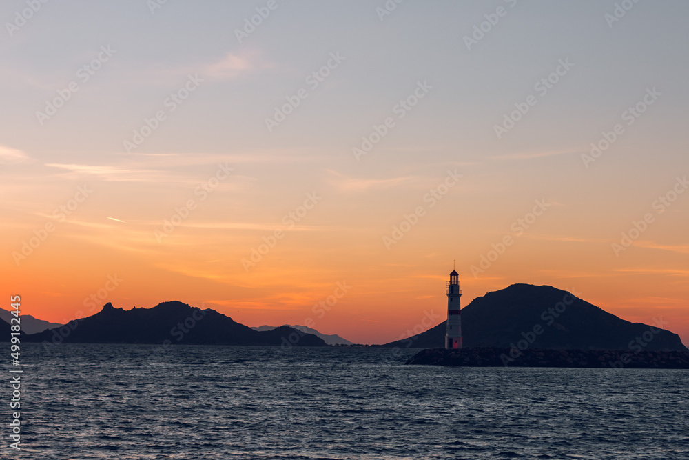 Seascape at sunshine. Lighthouse and sailings on the coast. Turgutreis Lighthouse at Sunset. Deniz Feneri.