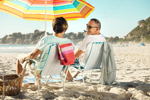 Leave your worries behind and head for the beach. Shot of a couple sitting on their chairs while enjoying a day at the beach.