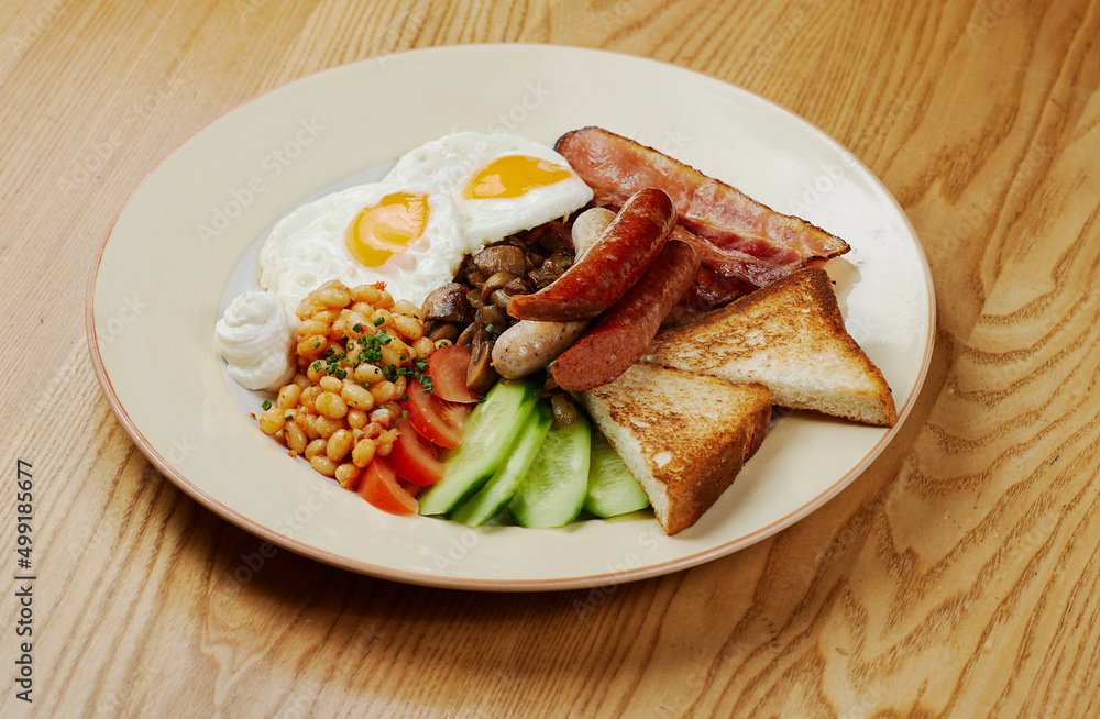 german breakfast of sausages, bacon, eggs and vegetables
