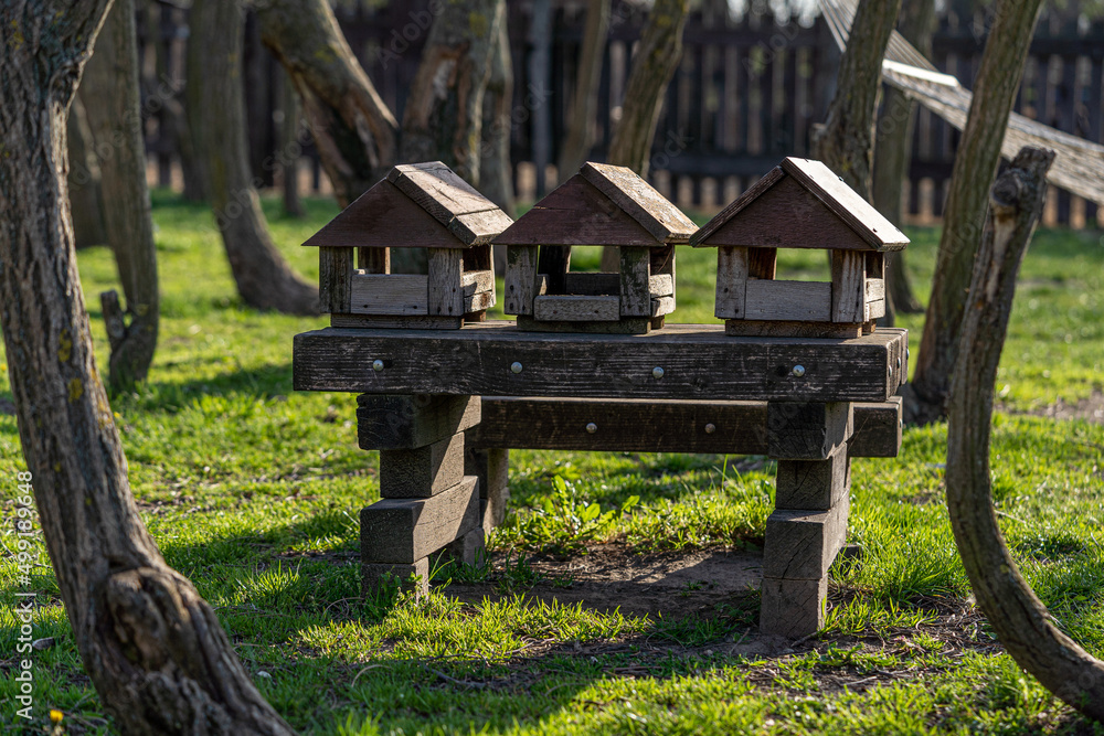 three bird feeders in the form of a house on the table three bird feeders in the form of a house on the table