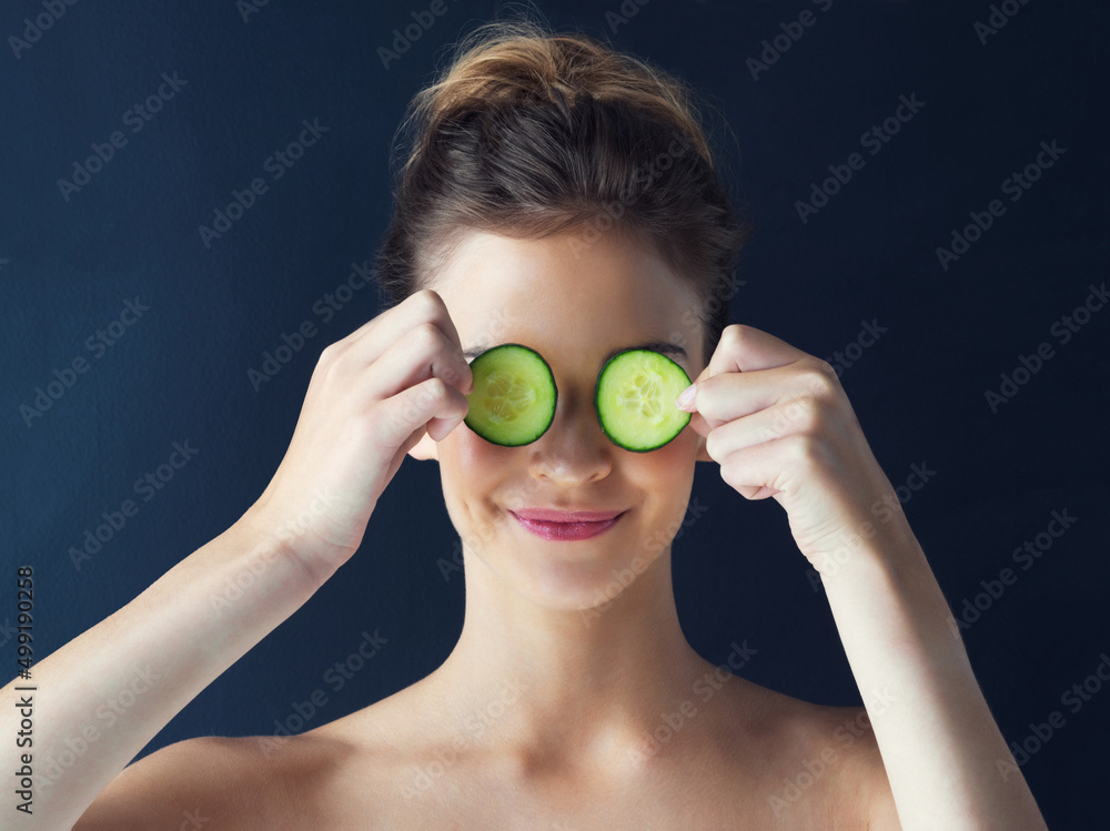 Nature inspires soft, pampered skin. Cropped shot of a beautiful young woman holding cucumbers over her eyes. Nature inspires soft, pampered skin. Cropped shot of a beautiful young woman holding cucumbers over her eyes.