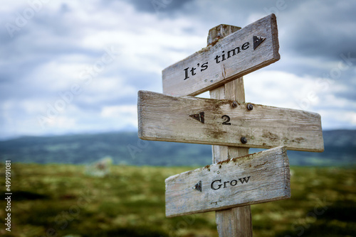 its time to grow text quote written in wooden signpost outdoors in nature. Moody theme feeling.