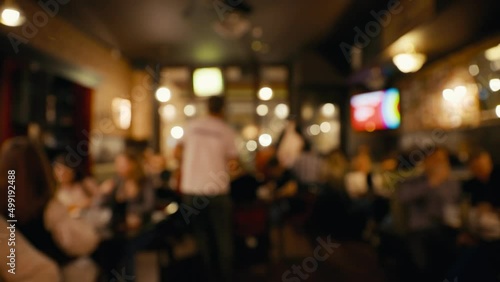 Blurry: Staff member collecting answers during bar quiz game at night party photo