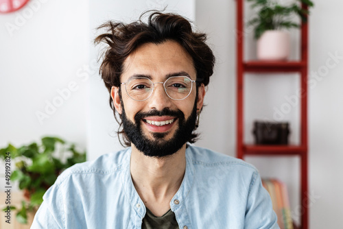 Portrait of confident and successful young entrepreneur freelancer smiling at camera on video call screen from home office