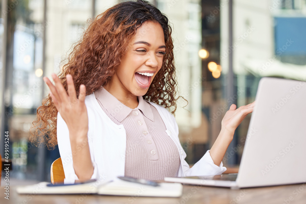 Dreams can come true. Shot of a young businesswoman looking excited while using a laptop at a cafe. Dreams can come true. Shot of a young businesswoman looking excited while using a laptop at a cafe.