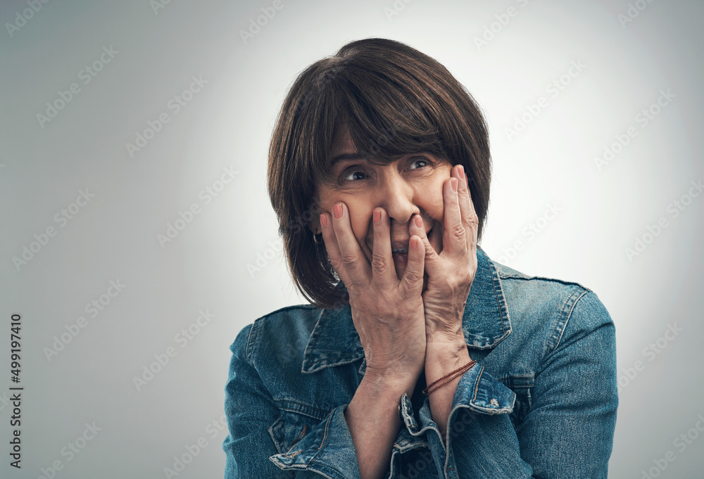 Oh the terror. Studio shot of a senior woman looking scared against a grey background. Oh the terror. Studio shot of a senior woman looking scared against a grey background.