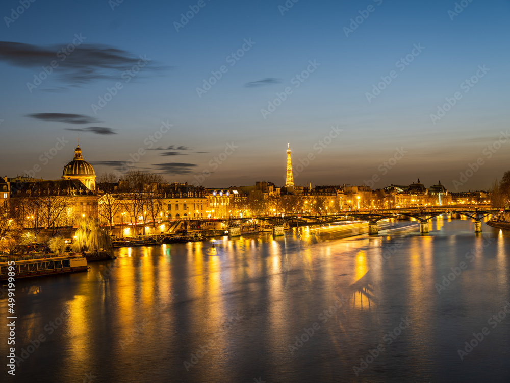 Pont des Arts bridge over River Seine and eiffel tower at night