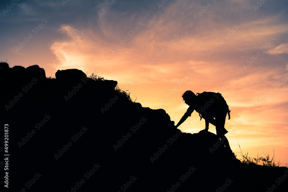 Mountain climber hiking up a steep cliff