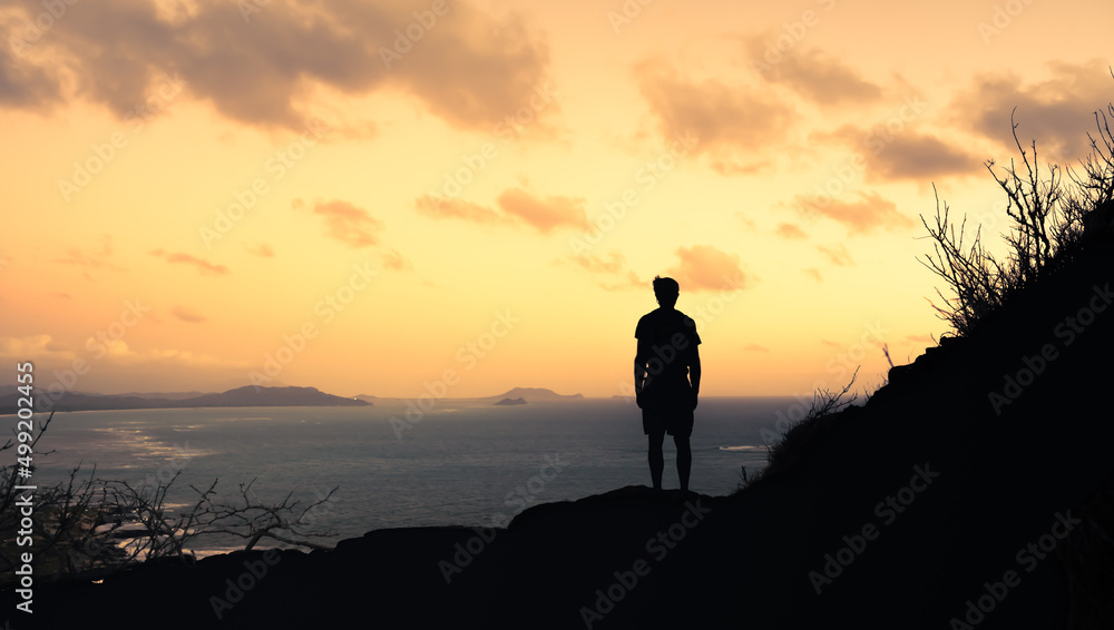 silhouette in young man on a mountain facing the sunrise 