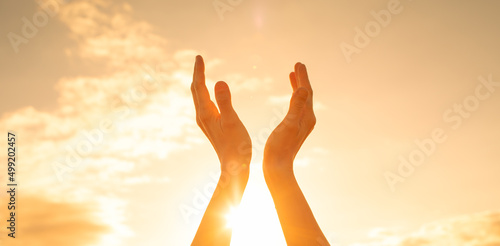 Person's hands up to the sun light. feelings of hope and happiness concept 