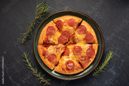 Hot and Spicy Pepperoni Pizza on black plate, Pepperoni Pizza on black plate on black background,