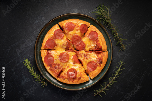 Hot and Spicy Pepperoni Pizza on black plate, Pepperoni Pizza on black plate on black background,