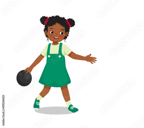 cute little African girl playing bowling in the sport club ready to throw the ball