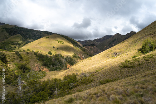 Mountain valley illuminated by sunbeams on a cloudy day, Chile