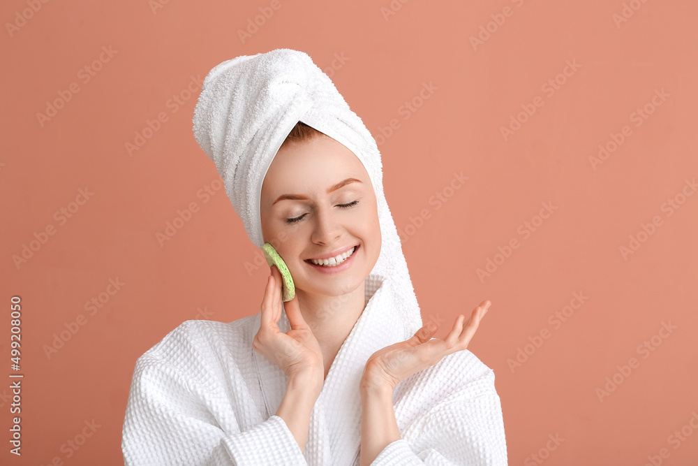 Young woman with makeup sponge on color background Young woman with makeup sponge on color background