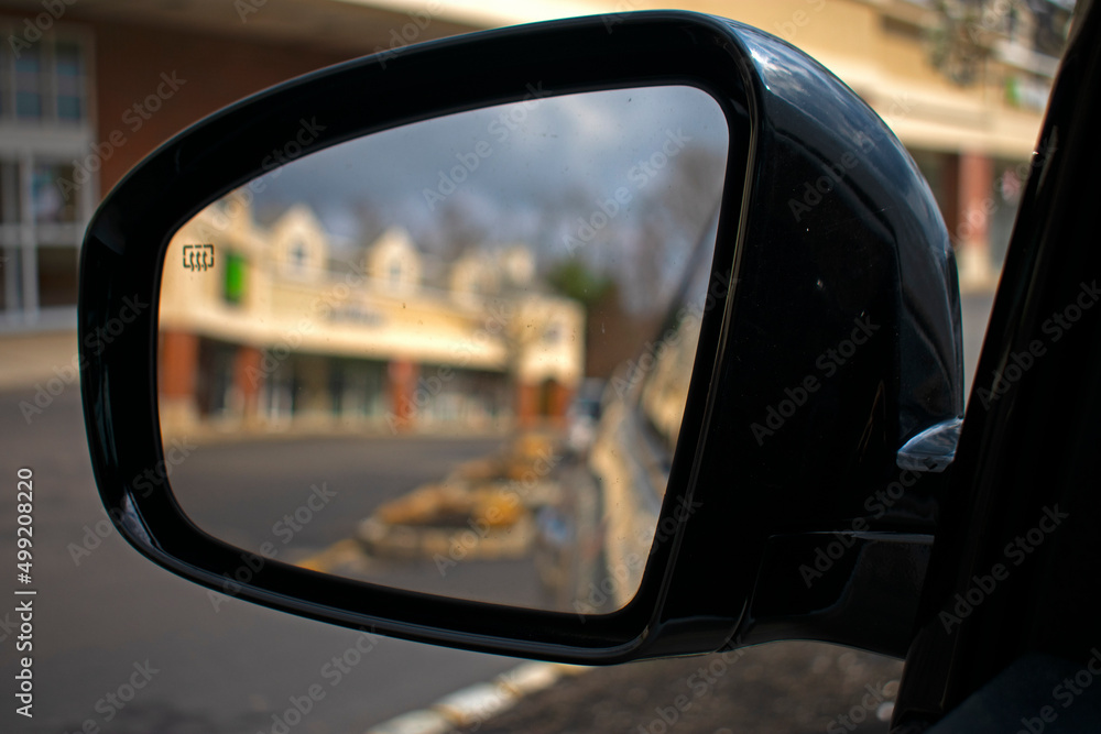Strip mall shops reflected through an automobile's side view mirror with close focus -03