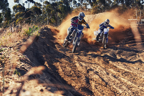 Time to rip up this track. Shot of two motocross racers in action.