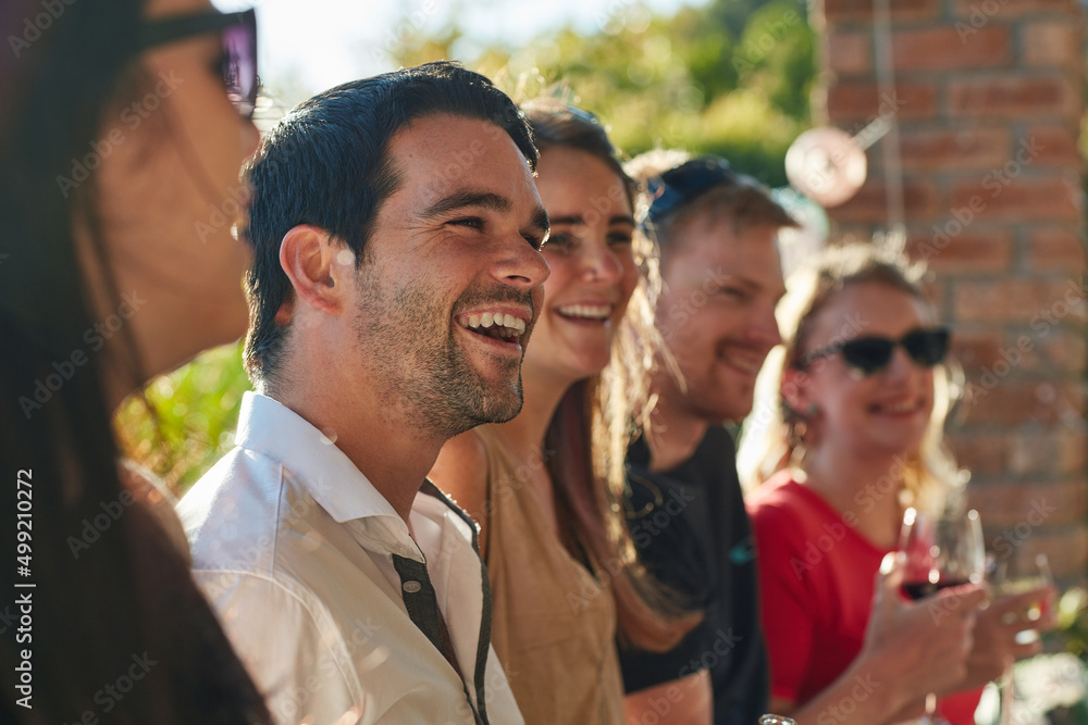 Fototapeta premium Life is better when shared with friends. Shot of a group of happy young friends hanging out at a backyard dinner party.