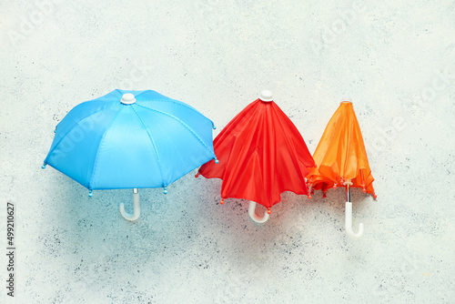 Different umbrellas on light background © Pixel-Shot