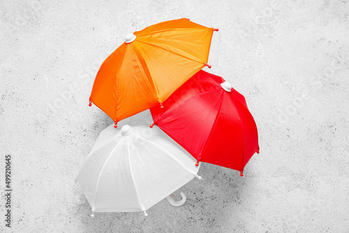 Different mini umbrellas on light background © Pixel-Shot