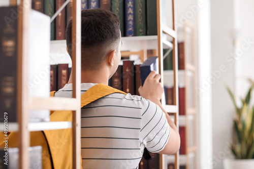 Male student taking book fr...