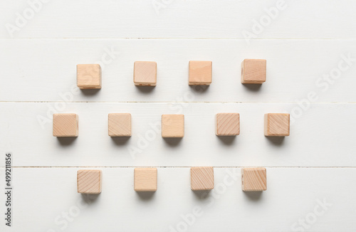 Cubes on white wooden background, top view