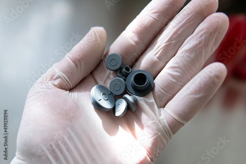 pharmaceutical stopper on the background of gloved hands..