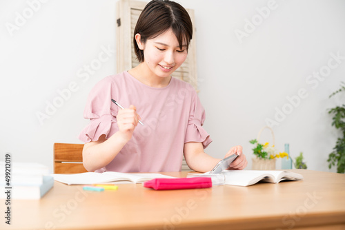 スマートフォンを観ながら勉強をする女性