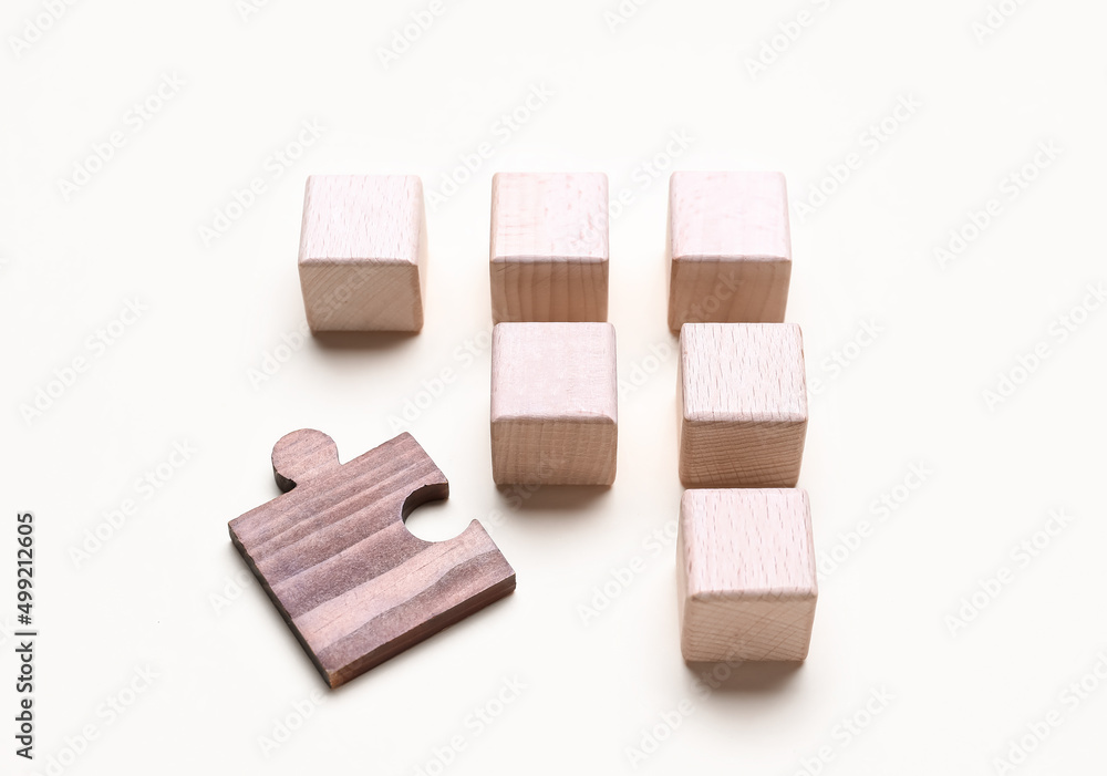 Wooden cubes with letters and puzzle piece on white background Wooden cubes with letters and puzzle piece on white background