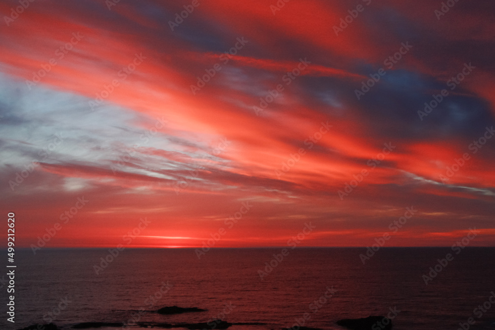 オレンジ色の雲がきれいな夕暮れの海
