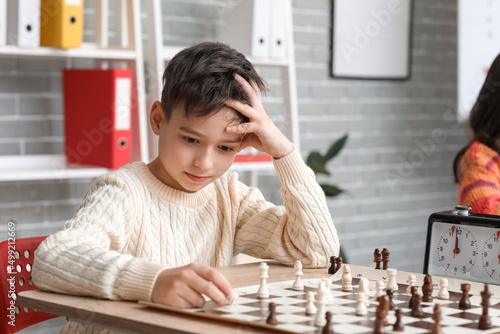 Little boy playing chess du...