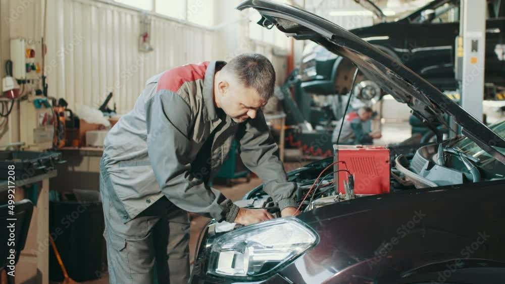 Mechanic man examining and maintenance to customer the engine a vehicle car hood, Safety inspection test engine, transportation repair service center. Auto service, repair, maintenance concept Mechanic man examining and maintenance to customer the engine a vehicle car hood, Safety inspection test engine, transportation repair service center. Auto service, repair, maintenance concept