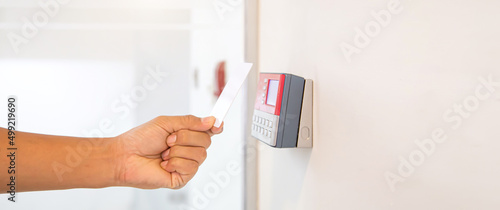 Proximity card reader door unlock, Close up hand security man using ID card scanning at the access control system for identity verification to open the door or for security safety or check attendance. photo