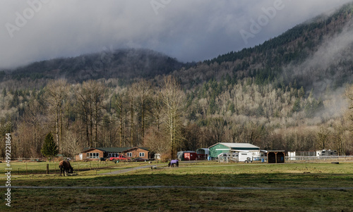Farming scene - country house and barns with mountains in background 