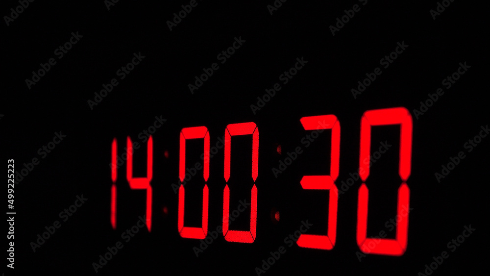 Digital timer on a black background. Light panel with red numbers