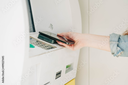 Woman withdraws money from a phone at an ATM.