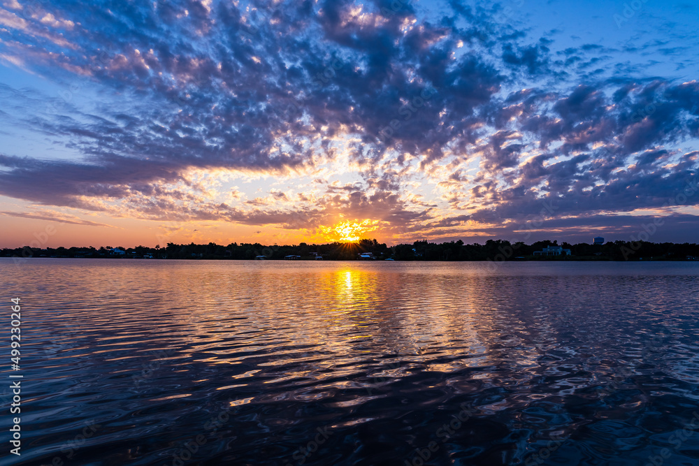 Fototapeta premium A pink sunrise over the Saint Sebastian River on an overcast day in Little Hollywood, Mikko, Florida. Dramatic colors of nature on a Florida morning