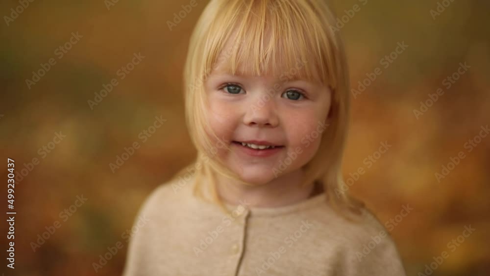Happy beautiful baby girl with blonde hair laughing in the autumn park Happy beautiful baby girl with blonde hair laughing in the autumn park