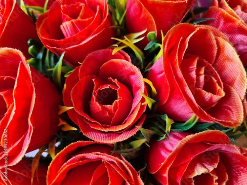 Red artificial roses with greenery for background