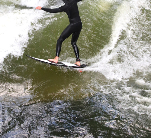 surfer athlete with wetsuit rides the waves while staying in balance