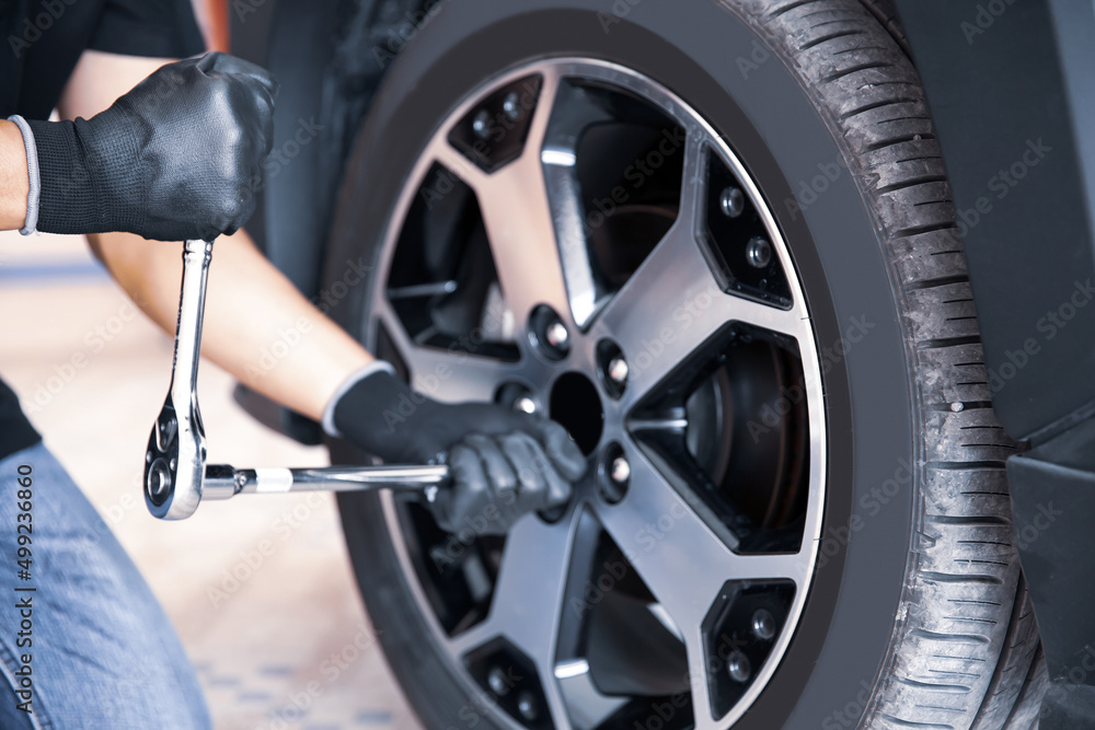 Auto mechanic use wrench to repairing and change car tires. Concept of car care service and maintenance or fix the car leaky or flat tire. Auto mechanic use wrench to repairing and change car tires. Concept of car care service and maintenance or fix the car leaky or flat tire.