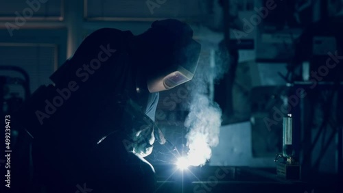 Welder wearing a protective mask welding metal
