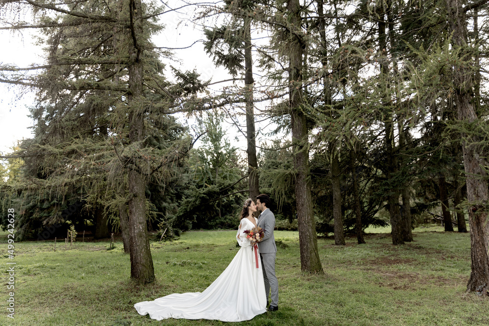 Beautiful wedding couple hugging in the forest