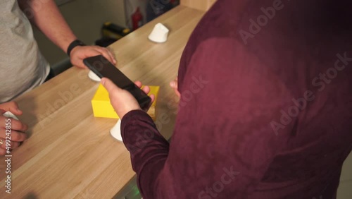 man looking at cell phone in store